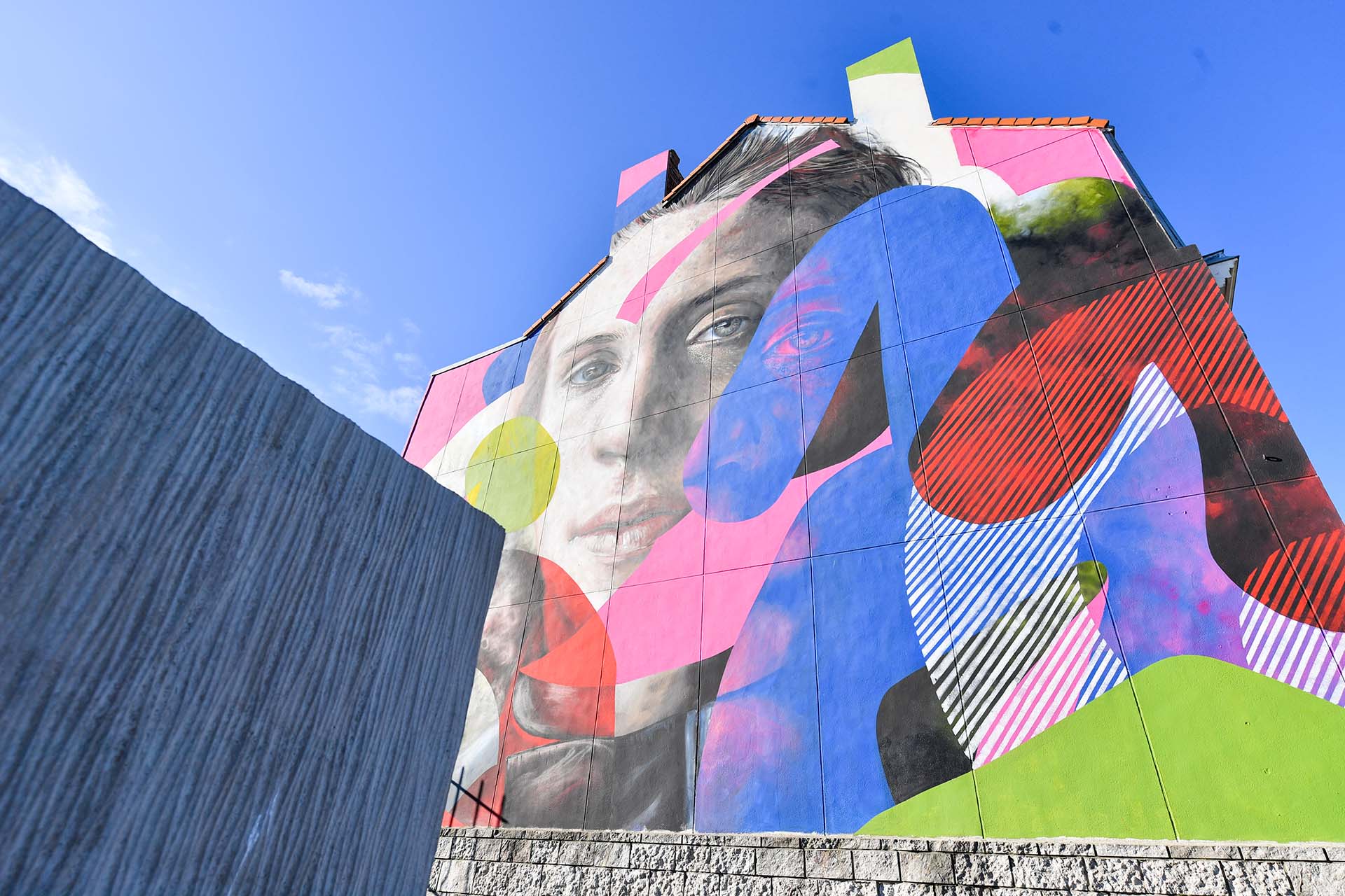 Fresque de street art à Calais représentant un visage et des lignes colorées